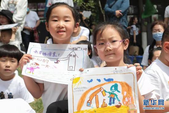 5月28日,兰州市城关区保育院学生在活动现场展示手绘作品。新华社记者 马希平 摄