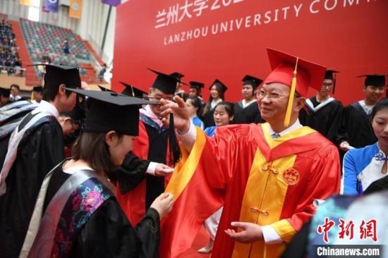 图为兰州大学校领导、学院主要负责人、优秀教师代表为毕业生授学位。 杨艳敏 摄