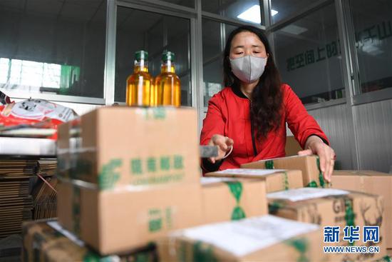 梁倩娟将客户订购的农产品打包,准备快递发运(3月8日摄)。新华社记者 陈斌 摄