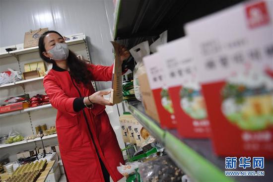 梁倩娟在自己的电商服务点整理货架上的农产品(3月8日摄)。新华社记者 陈斌 摄