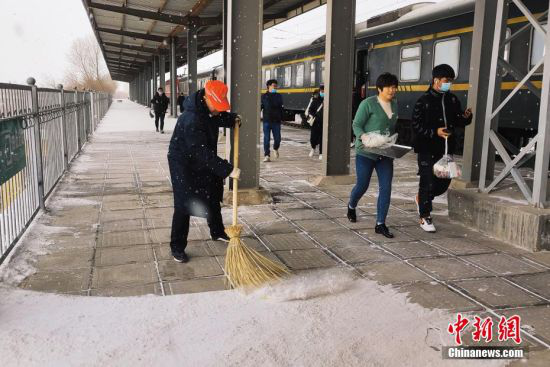 工作人员清扫站台上的积雪。强科 摄