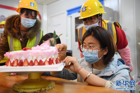 杜萱(右一)和女工友一起在工地上制作蛋糕庆祝“三八”妇女节(3月4日摄)。新华社记者 杜哲宇 摄