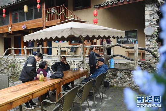 3月17日,游客在陇南市康县岸门口镇朱家沟村的一家民宿里聊天。新华社记者 陈斌 摄