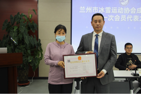 兰州市民政局主任曹淑莉(左)宣读准予成立的批复并颁发证书