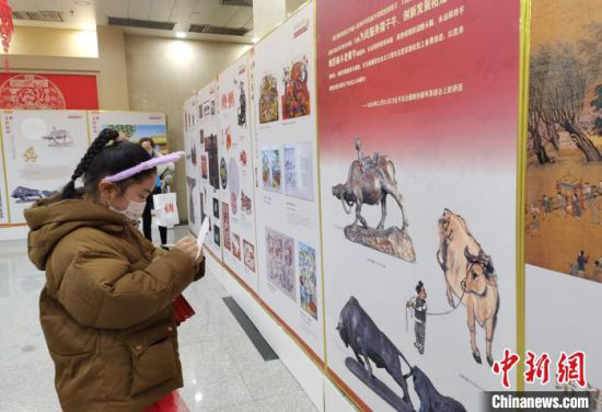 图为今年9岁的李蕊涓驻足于生肖文物联展前,用随身携带的纸笔做学习记录。 张婧 摄