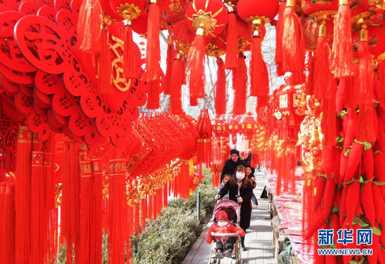 1月31日,顾客在永靖县刘家峡镇一市场挑选节庆饰品。新华社发(史有东 摄)