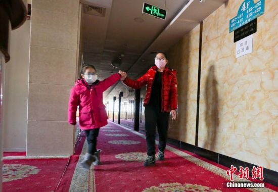 图为甘肃张掖首批湖北籍游客“解禁”第一天,湖北籍游客与女儿高兴的在楼道里散步。