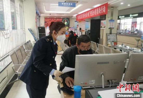 图为兰州市西固区税务局办税大厅,税务工作人员指导纳税人网上办税。西固区税务局供图