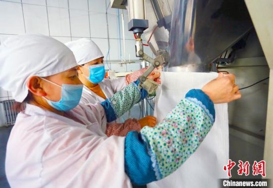 庆阳中庆农产品有限公司生产车间里工作人员正在加工农特产品。