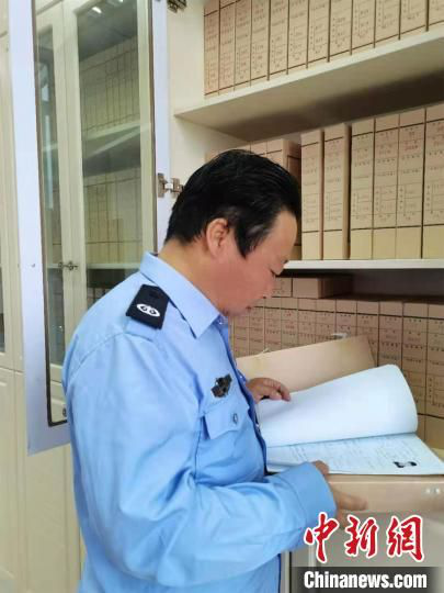 图为史继峰查看社区矫正对象的材料。定西市司法局供图