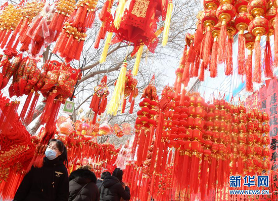 1月31日,顾客在永靖县刘家峡镇一市场挑选节庆饰品。新华社发(史有东 摄)