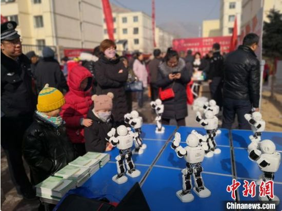 图为七里河区科技局带来的机器人表演吸引小朋友观看。