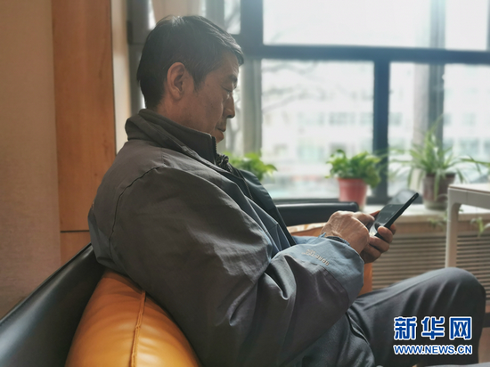 尹春元在使用智能手机。新华社记者 何问 摄