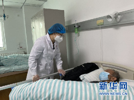 张荣霞(左)在白银市中西医结合医院感染科与住院患者交流(新华社记者 程楠 摄)