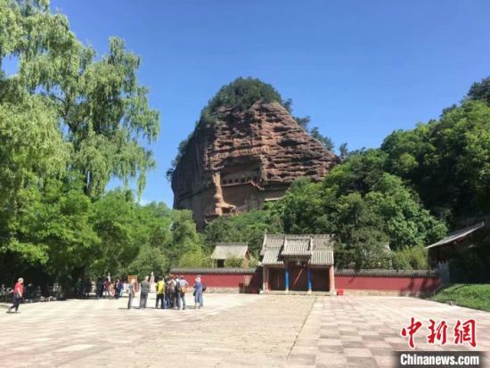 4月1日,位于甘肃省天水市的世界文化遗产麦积山石窟恢复开放。图为2018年盛夏,游客在该景区游览。