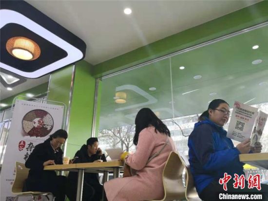 图为2018年冬日,兰州市民在装修一新的粮店内喝着杂粮热饮享受午后时光。