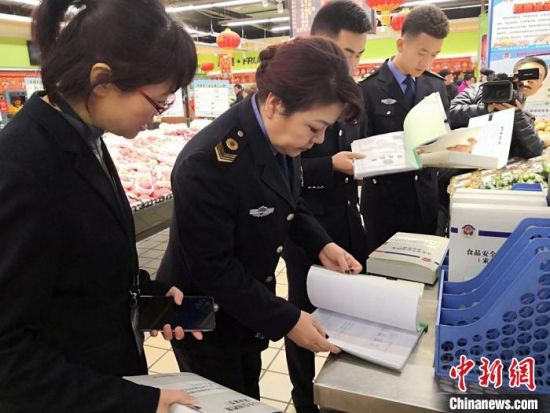 图为2019年1月,兰州食品药品监管部门检查超市商品。