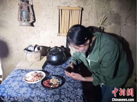 图为宕昌磨河坝村农家女,用手机录制烹饪“山味”的视频,与生活在都市的网友们分享。