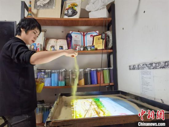 图为朱晓玲挥沙作画。 崔琳 摄