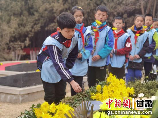 图为小学生为烈士敬献鲜花。