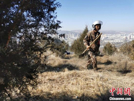 3月初,定西市永定村护林员拿着铁锨“巡山”。 闫姣 摄