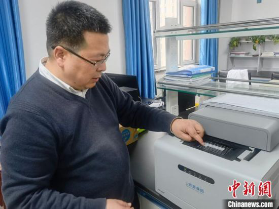 车团结向记者介绍ASA-9600实时荧光定量PCR仪器工作原理。 高康迪 摄