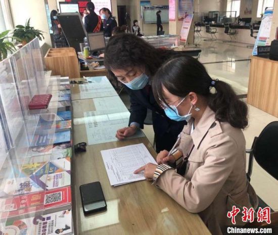 图为税务工作人员指导纳税人办税。西固区税务局供图