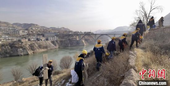 图为职工们携带检修、检测设备准备上桥。 魏建军 摄