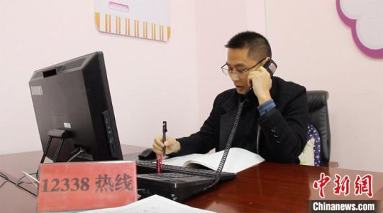 3月上旬,傅智勇正在接听热线电话。 高莹 摄
