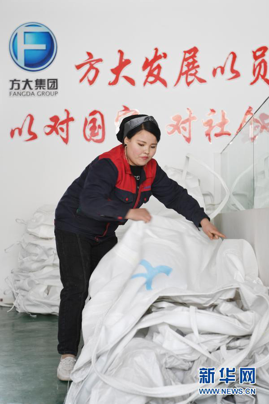 在东乡族自治县大树乡南阳洼村扶贫车间,马林红整理集装袋(3月4日摄)。新华社记者 范培珅 摄