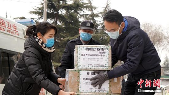 图为工作人员搬运防疫物资。