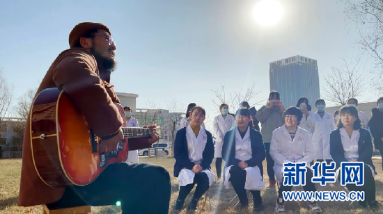 张尕怂(左一)为白银市中西医结合医院的医护人员代表演唱(新华社记者 程楠 摄)