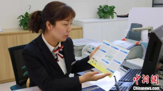 图为银行工作人员向顾客介常见的诈骗信息。(资料图) 德吉卓玛 摄