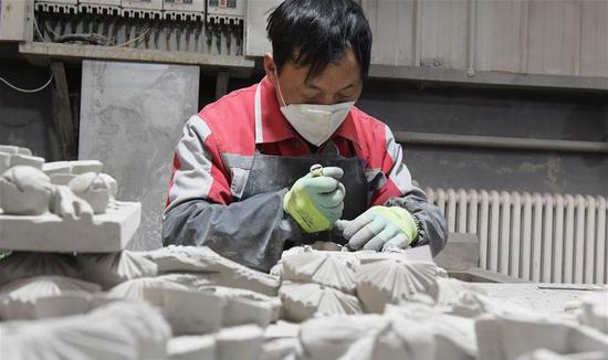 12月8日,在甘肃省临夏回族自治州临夏县一非遗扶贫就业工坊,艺人在制作砖雕作品。新华社发(史有东 摄)