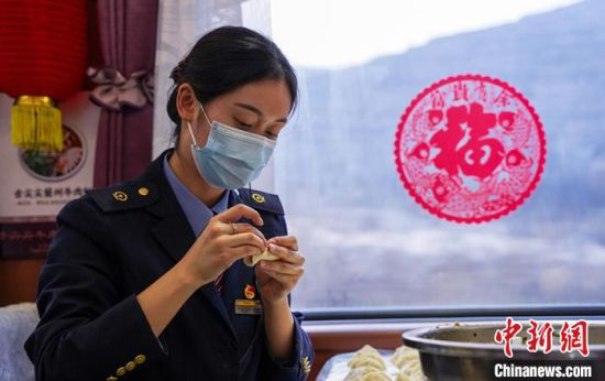 图为兰州客运段乘务人员在餐车内包饺子、过新年。 田多伟 摄