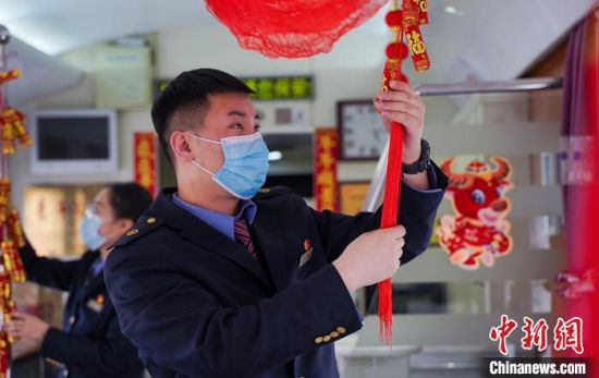 图为兰州客运段乘务人员在餐车内粘“福”字,贴窗花。 田多伟 摄