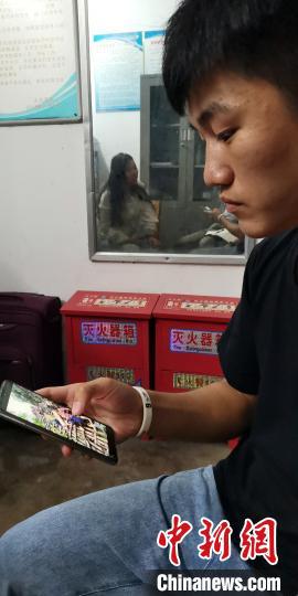 蒙宣任在辨认新闻照片上的同伴。 蒋雪林 摄