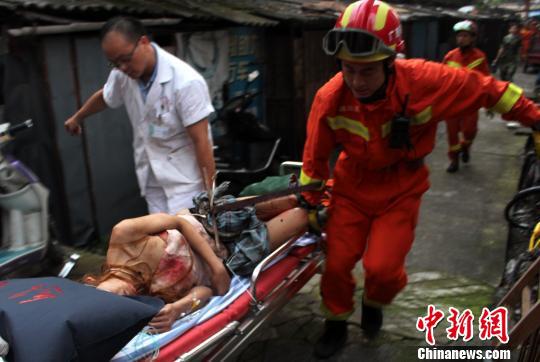 图为消防官兵与医护人员一起将受伤女子抬到120救护车上。 焦晓佳 摄