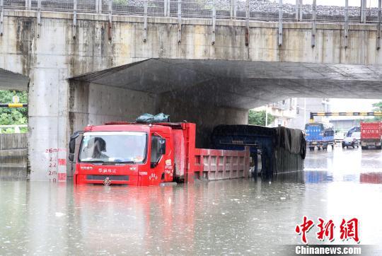 停放在涵洞中的货车,泡在水里。 朱柳融 摄