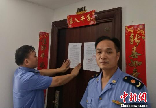 图为执法人员对该房产进行查封。 陈立群 摄