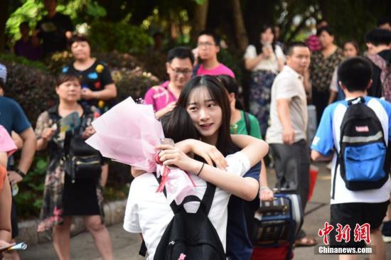 资料图:一名家属拥抱走出考场的考生。 王以照 摄