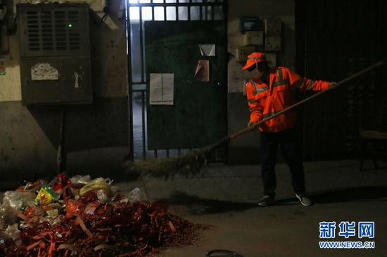 大年初一凌晨,南宁市西乡塘区环卫站华强片区队长陈色南在华兴里街道清理小区的垃圾。(2月5日拍摄)