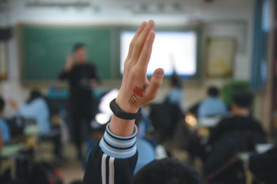 ▲2018年12月25日,北京市海淀寄读学校的学生在课堂上举手提问。 新京报记者 吴江 摄