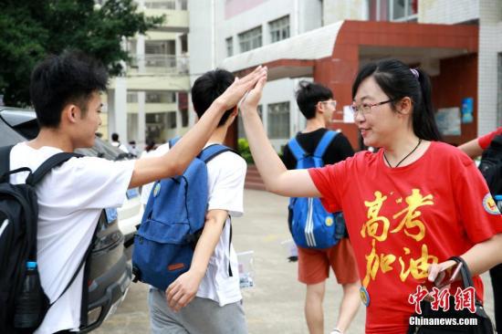 图为老师穿着印有“高考加油”字样的服装,与学生击掌。朱柳融 摄