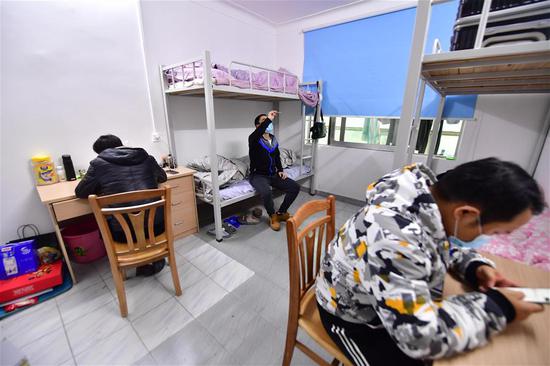 广西桂林南溪山医院救护队司机温擎(中)在宿舍测量体温(2月7日摄)。 新华社记者 黄孝邦 摄