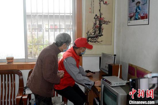 3月5日,志愿者上门为独居的老人修理电脑。 孙赟飞 摄