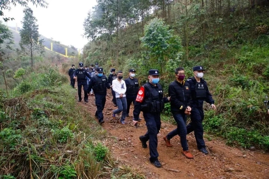 图为移民管理警察押解犯罪嫌疑人指认现场。