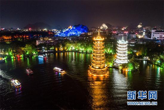(游人乘船在桂林杉湖的日月双塔附近游览。新华社记者李鑫摄)