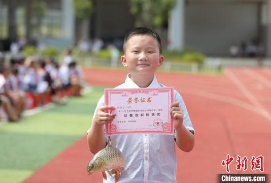 一名学生在展示自己的特殊奖品。 龚普康 摄