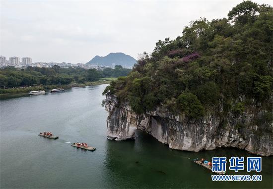 (游人乘船在桂林象鼻山附近游览。 新华社记者李鑫摄)